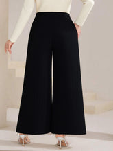 Plus size high waist wide leg black trousers with smooth flowing fabric and button decor detail