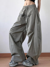 Gray drawstring oversized wide leg casual pants with prettygirl embroidered in black script across the thigh