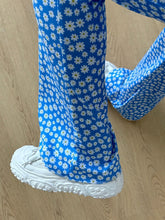 Blue floral print flare leg pants with white daisy prints featuring a wide-leg design for stylish comfort