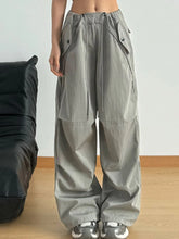 Gray wide leg drawstring pants featuring a relaxed fit and multiple large cargo pockets for utility and style