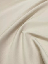 Cream-colored smooth fabric with subtle sheen and folds in plus size relaxed fit casual pants
