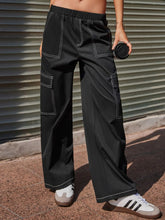 Black cargo wide leg pants with white contrast stitching and a relaxed wide leg cut