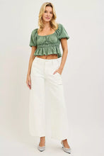Green ruched short-sleeved crop top paired with risen high rise ankle wide pants featuring gathered fabric details