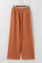 Pink and orange vertically striped wide leg pants with elastic waistband featuring stripe button pocket tie details