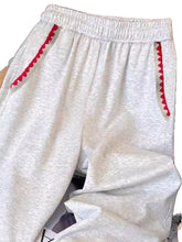Light gray heathered casual loose fit embroidered sweatpants with red zigzag trim along side pockets