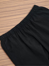 Black elastic waist pants made of smooth lightweight fabric featuring pockets for comfortable everyday wear