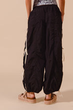 Black loose fit jogger pants so me with white drawstrings, elastic cuffs, and double lined side detail