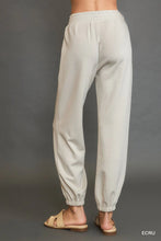 Beige umgee drawstring jogger pants with elastic waist tapered legs and ribbed cuffs featuring front seam detail