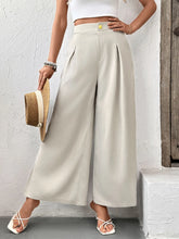 Beige slit wide leg pleated pants with high waist, pleated front, and small gold button at the waistband