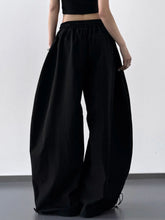 Black wide leg drawstring pants with elastic waistband and ankle ties for comfortable casual wear
