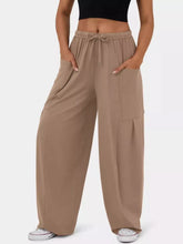 Beige drawstring wide leg pants with cargo pockets and a comfortable adjustable waist for casual wear