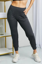 Black high-waisted cropped joggers with wide waistband elastic cuffs and side pockets from Leggings Depot