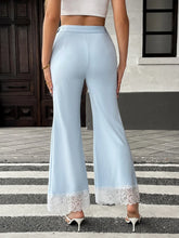 Light blue satin flare leg pants featuring delicate white lace trim at the hem for an elegant look