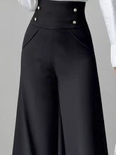 Black high waist wide leg trousers with gold toned buttons at the waistband for a stylish elegant look
