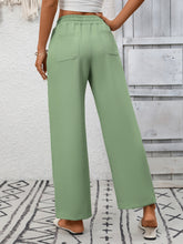 Light green casual drawstring wide leg pants with elastic waistband and two back pockets shown from the back side