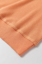 Peach V-neck long sleeve waffle knit top with orange texture and ribbed cuffs