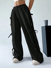 Black cargo wide leg pants featuring side tie details designed for a stylish and functional look