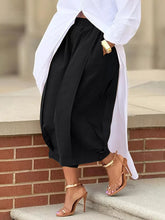 Black high-waisted wide leg pleated trousers with a relaxed silhouette and elasticated waistband for comfort