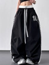 Black lace detail drawstring wide leg pants with white lace trim and silver number 18 on the thigh