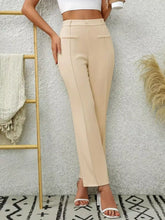 Beige high waist flare pants with tailored fit and front pockets made from soft fabric for a polished look
