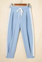 Light blue wide leg pleated joggers with white lace accent floral trim and matching drawstring waistband