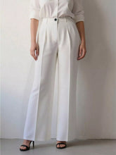 White high-waisted wide leg pants with pleated detailing and a sleek minimalist design for elegant wear