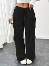 Black cargo pants with drawstring waist and side pockets featuring a casual drawstring loose fit design