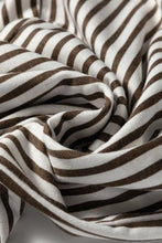A soft flowing scarf with bold brown and white vertical stripes paired with stripe elastic high waist pocketed loose pants
