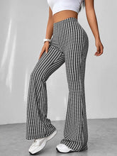 High waisted flare pants in black and white houndstooth pattern featuring a high waisted flare silhouette