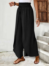 Black high-waisted side slit wide-leg pants with smocked waistband and drawstring made of lightweight polyester fabric suitable for machine wash