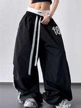 Black lace detail drawstring wide leg pants with white elastic waistband and silver 18 embroidery on thigh