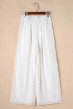 White flowing wide leg tie waist pleated pants with elastic waistband for comfortable stylish wear