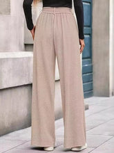 Beige wide-leg pants with elastic waistband made from soft textured fabric suitable for machine wash care instructions