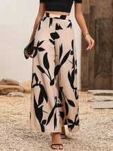 Beige printed wide leg pants featuring a bold black leaf pattern ideal for stylish casual wear