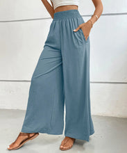 Light blue high-waisted wide leg pants with gathered elastic waistband and side pockets for comfortable wear