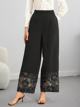 Black wide leg trousers with a sleek high waist and elegant floral lace hem wide detailing at the pant hem