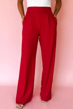 Red high-waisted wide-leg pants offer a smooth flowing fabric with pleated detail and a high elastic waist for comfort