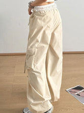 Cream-colored cargo wide leg pants with elastic waistband multiple side pockets and bow tie details