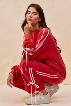 Red oversized sweatshirt with white striped detailing and matching drawstring ties complementing bow details fleece pants