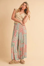 AemiCo wide leg pants featuring soft pastel patchwork with floral and geometric designs worn by a woman