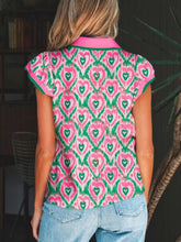 A vibrant pink and green short sleeve blouse with abstract heart print and contrasting bright pink striped trim polo collar