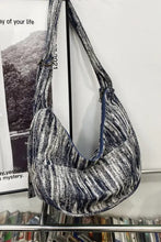 Distressed abstract canvas sling bag with zipper closure