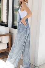 Acid wash denim overalls with frayed exposed seam wide leg
