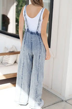 Women’s acid wash denim overalls with exposed seam wide leg and white tank top