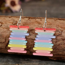 Colorful acrylic rainbow dangle earrings with spool-shaped stripes