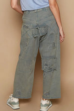 Distressed olive green wide leg denim pants with frayed patches and ripped details made from premium cotton denim