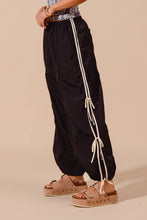 Black satin loose fit jogger pants with white drawstring and double lined side stripes for comfortable wear