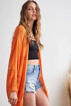 Adora lightweight sweater knit cardigan with relaxed fit, orange cable knit, denim shorts, black crop top