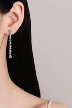 Woman wearing Adored 1.18 carat moissanite long earrings with dangling silver and clear gemstones