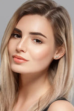 Woman with long blonde hair wearing Adored Your Way moissanite stud earrings